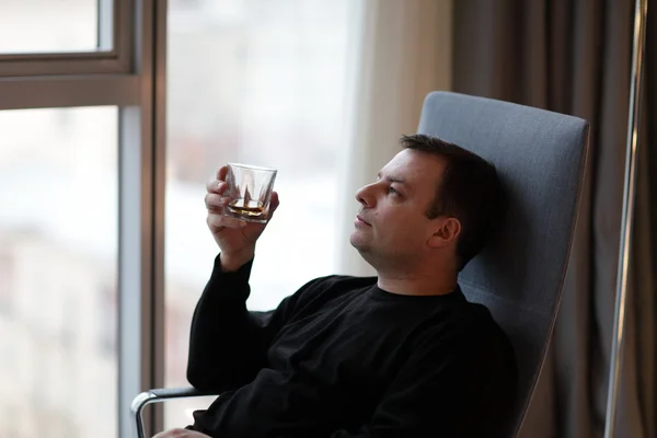 El hombre sostiene un vaso de whisky — Foto de Stock