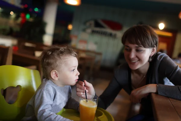 Mor giver at drikke sin søn juice - Stock-foto