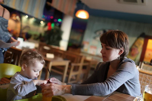 Annesi ona toddler suyu içmek için verir. — Stok fotoğraf