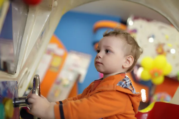 Ragazzo che gioca con la macchina del divertimento — Foto Stock