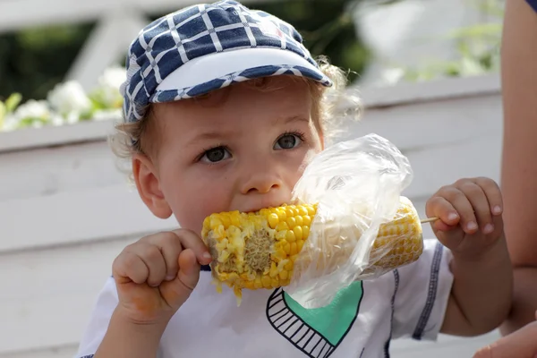 Toddler eating boiled corn — Stock Photo, Image