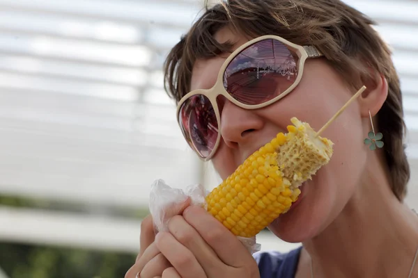Woman eating boiled corn — Stock Photo, Image