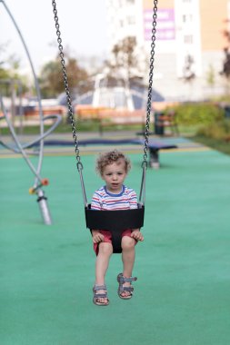 bir salıncak üzerinde yürümeye başlayan çocuk
