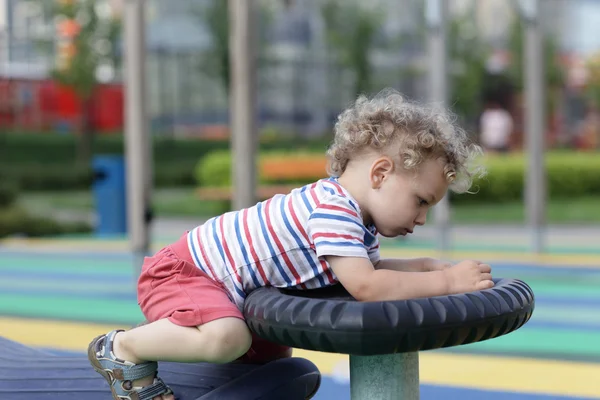 Niño jugando en el parque infantil — Foto de Stock