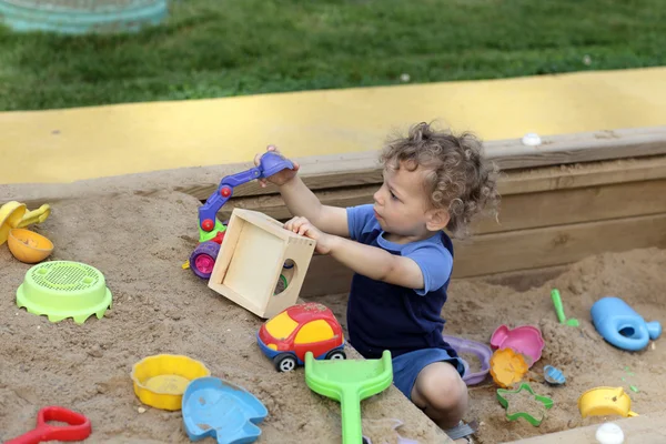 Lockigt pojke på sanden boxas — Stockfoto