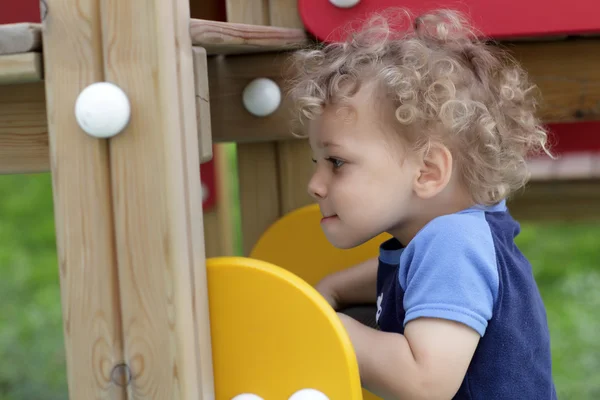 Curly child at wooden stairs — Stock Photo, Image