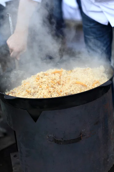 Muž vaření pilaf — Stock fotografie