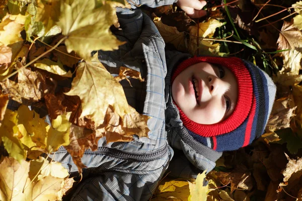 Kind liegt auf Laub — Stockfoto