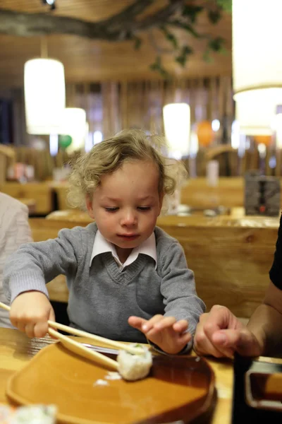 Niño tomando sushi — Foto de Stock