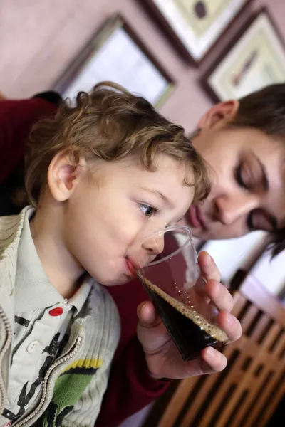 Mutter gibt Sohn zu trinken — Stockfoto