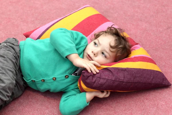 Niño está acostado en la alfombra — Foto de Stock