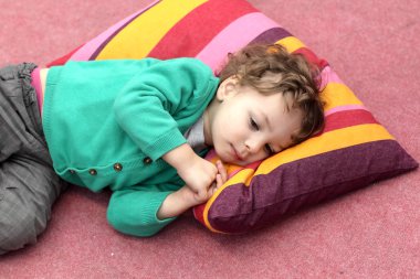 Çocuk halı üzerinde yalan söylüyor