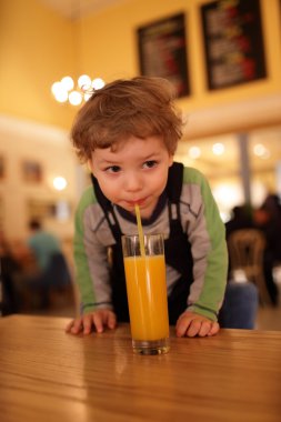 Çocuk portakal suyu içiyor.