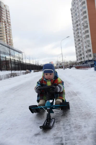 男孩幻灯片上雪滑板车 — 图库照片