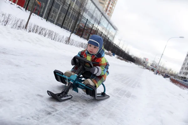 雪のスクーターの子スライド — ストック写真