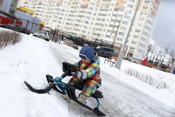 Kar scooter üzerinde yürümeye başlayan çocuk — Stok fotoğraf