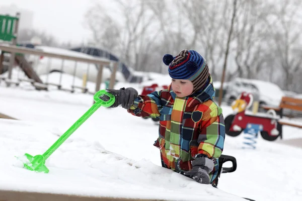 Мальчик играет со снегом — стоковое фото