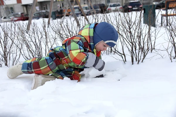 Peuter liggen in de sneeuw — Stockfoto