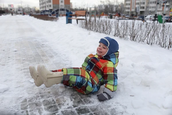 Dziecko siedzi w śniegu — Zdjęcie stockowe