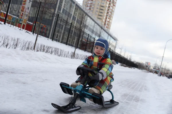 Kleinkind rutscht auf Schneescooter — Stockfoto