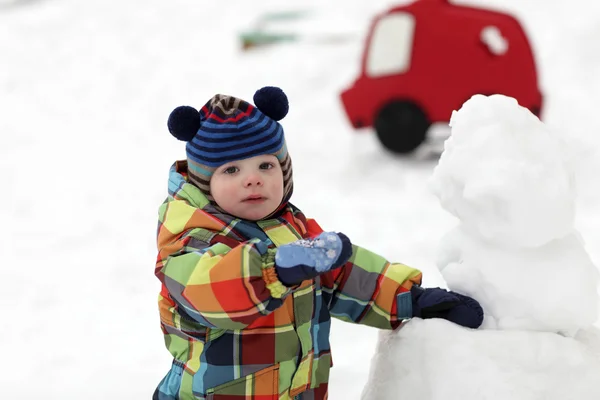 Criança faz um boneco de neve — Fotografia de Stock