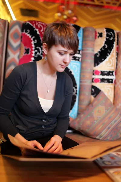 Woman with menu in uzbek restaurant — Stock Photo, Image