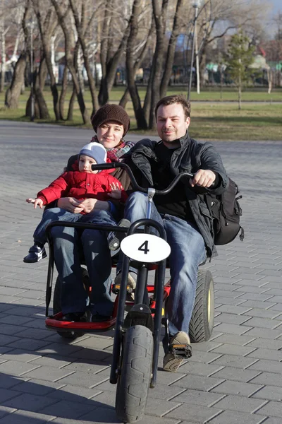 Famiglia in sella a una bicicletta a tre ruote — Foto Stock