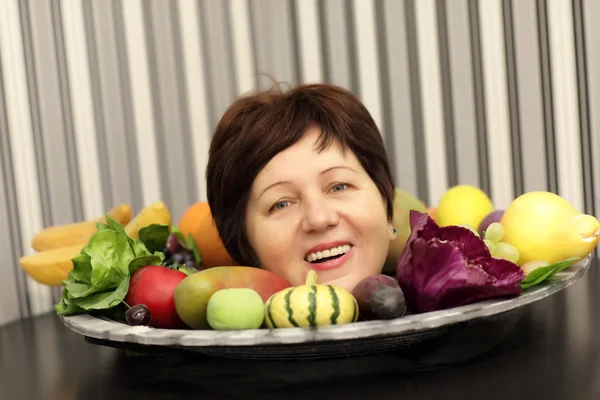 Счастливая женщина и тарелка фруктов — стоковое фото
