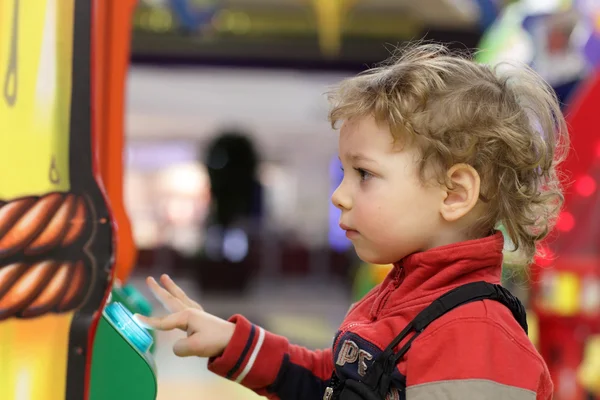 Kid jogando na máquina de jogo — Fotografia de Stock