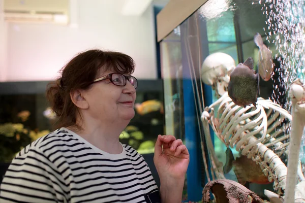 Mulher sênior assistindo peixes — Fotografia de Stock