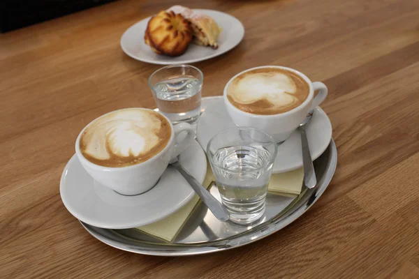 Glasses of coffee with water on tray — Stock Photo, Image