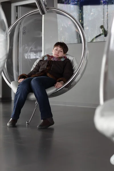 Woman posing in glass chair — Stock Photo, Image