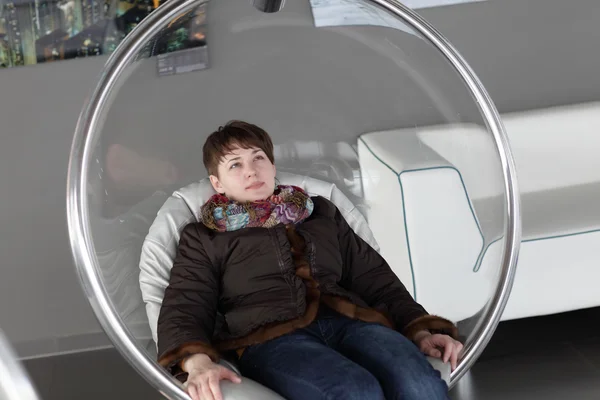 Woman relaxes in glass chair — Stock Photo, Image