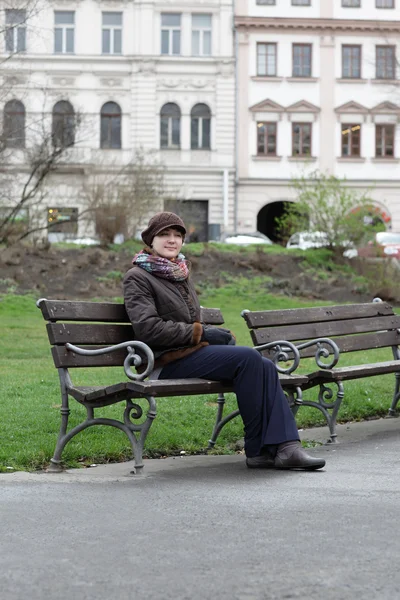 Femme assise sur un banc — Photo