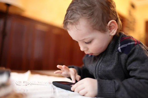 Мальчик играет на смартфоне — стоковое фото