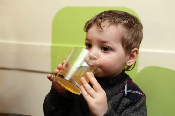 Boy drinks fruit tea — Stock Photo, Image