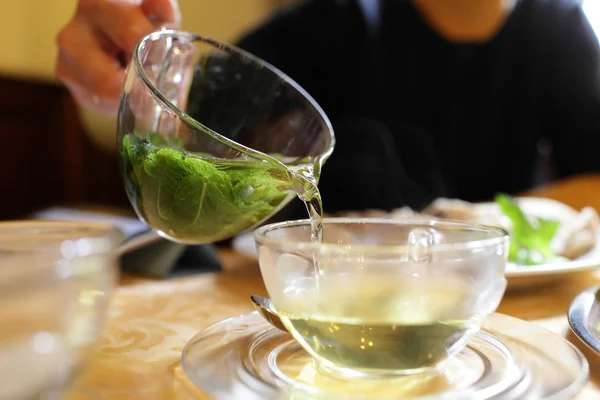 Vrouw gieten mint thee — Stockfoto