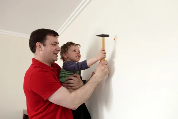 Family hammering plastic anchor — Stock Photo, Image