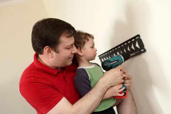 Pai e filho instalando montagem TV — Fotografia de Stock