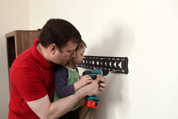 Pai com filho instalando montagem TV — Fotografia de Stock