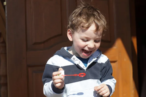 Мальчик играет с мыльным пузырём — стоковое фото