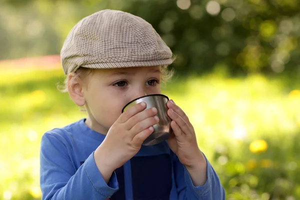 Niño bebiendo té al aire libre —  Fotos de Stock