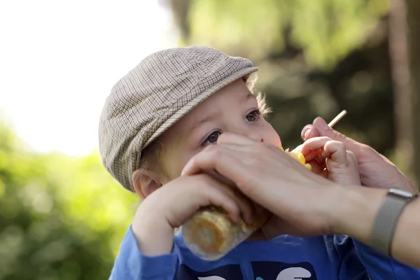 Niño hambriento comiendo maíz — Foto de Stock