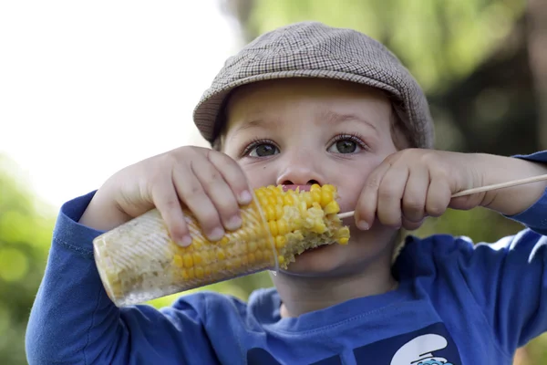 Hungry kid eating corn — Stock Photo, Image