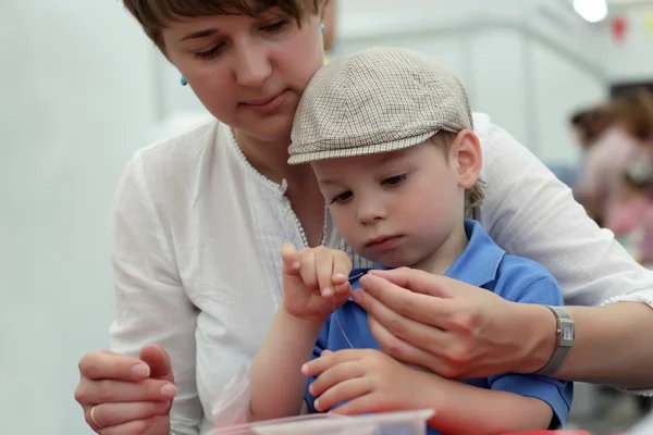 Child making bracelet — Stock Photo, Image