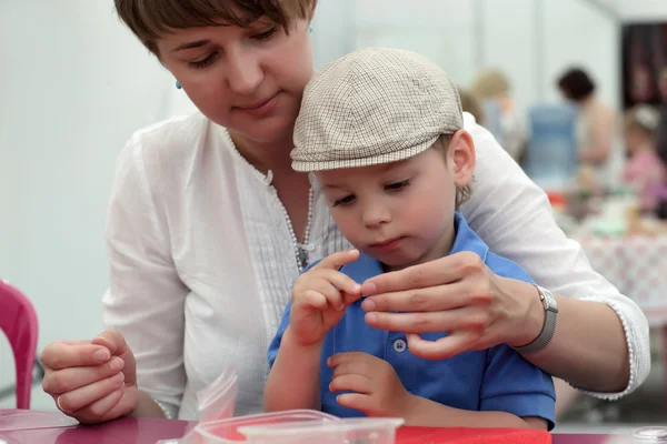 Mother and son making bracelet