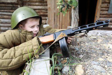 Çocuk siperde PPSh-41 hafif makineli tüfek ateşliyor.