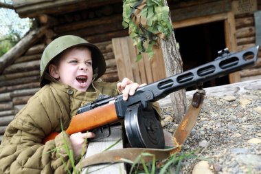 Bağıran çocuk siperde PPSh-41 hafif makineli tüfekle ateş ediyor