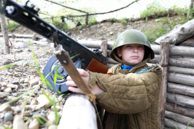 Siperdeki PPSh-41 makineli tüfekli çocuğun portresi.