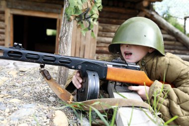 Siperde PPSh-41 makineli tüfek kullanan çocuk.